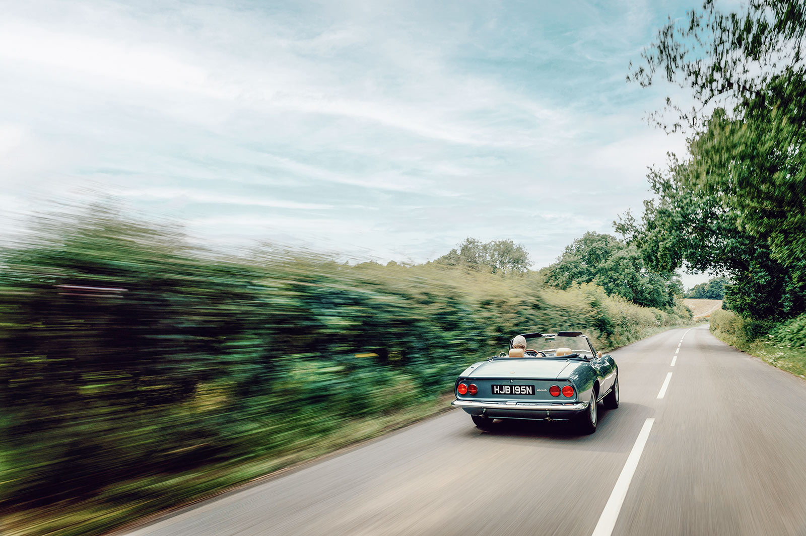 Fiat Dino Spider mit geöffnetem Verdeck auf Landstraße
