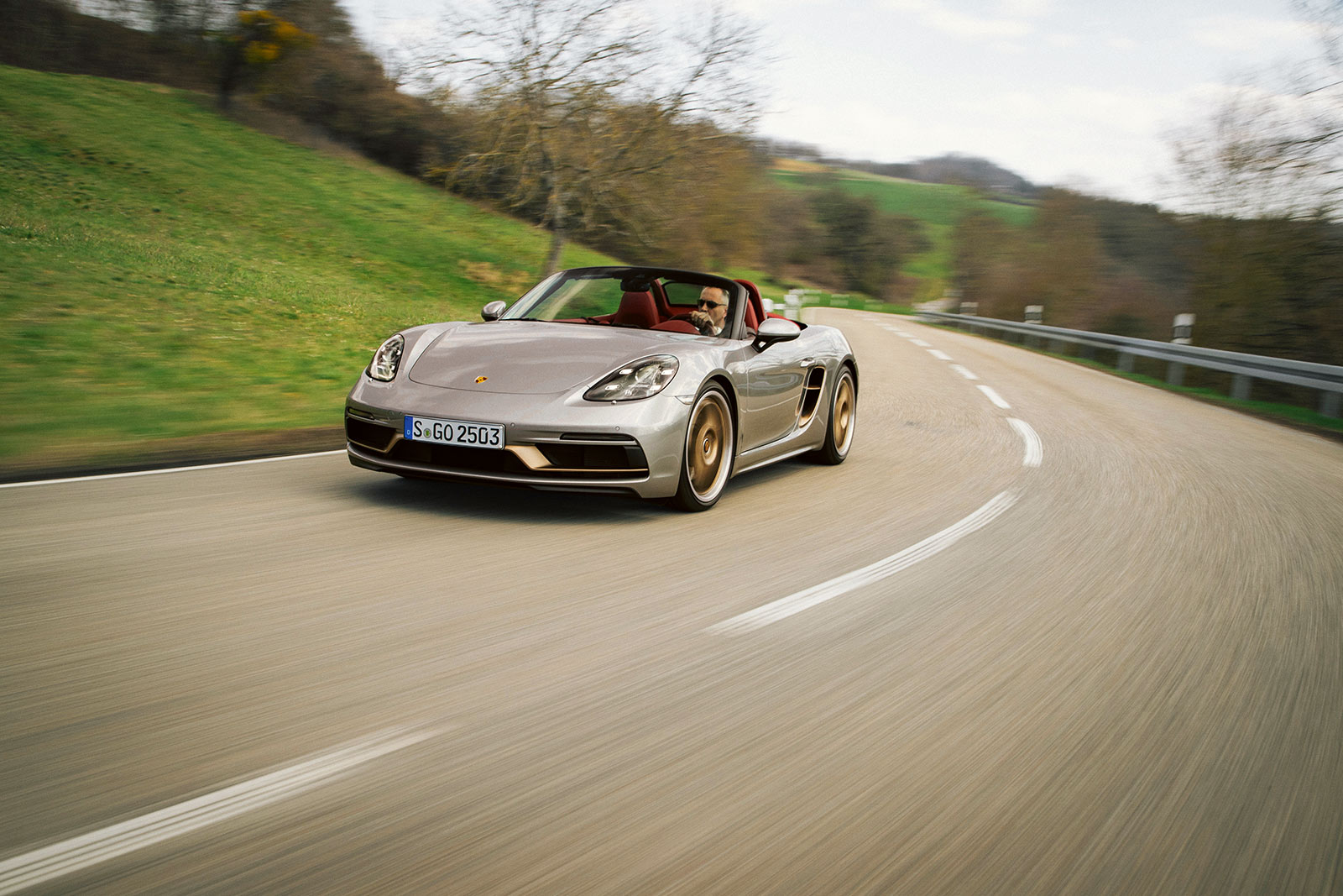 Porsche Boxster 986 auf kurviger Landstraße bei Sonnenschein