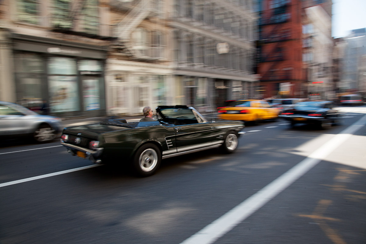 Ford Mustang Cabrio fahrend von schräg hinten