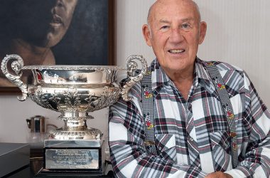 Stirling Moss posiert neben einem Pokal