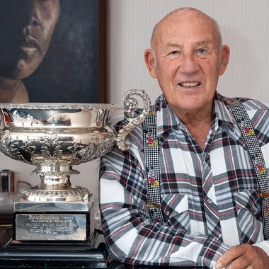 Stirling Moss posiert neben einem Pokal