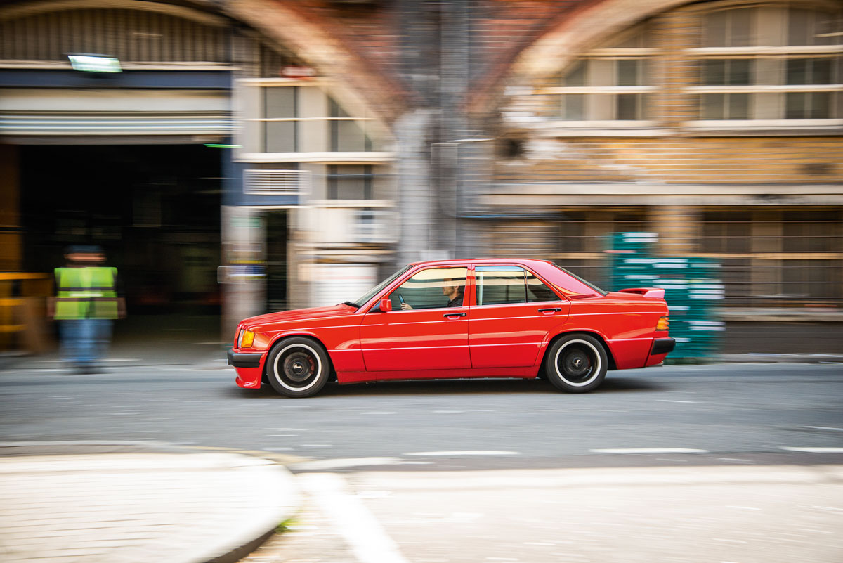 Der Anblick des halbstarken Mercedes 190, der gerade die Straßen im Londoner Süden unsicher macht, könnte Erinne- rungen wecken an die 1980er-Jahre und eher fragwürdige Tuning-Experimente im Zeichen des Sterns. Doch ist dieser Baby-Benz nicht nur wegen seines heute sechsstelligen Preises etwas Besonderes: Weil er all das verkör- pert, wofür das am Heckdeckel prangende Logo seines Erbauers – Brabus – in jener Zeit stand. Das Auto erntet viel Aufmerksamkeit von Pas- santen, auch von jenen, die zum Zeitpunkt seines Aufbaus noch nicht mal geboren waren. Doch ist es weniger der Wert des Wagens, der sie so beein- druckt. Sondern der ultracoole Retrolook. Von Graswurzeln-Anfängen und der Grün- dung von Brabus im Herbst 1977 ausgehend machte der BWL-Student Bodo Buschmann im Zuge seiner eigenen Professionalisierung das in gewissen Kreisen damals noch verpönte Tuning salonfähig. Zug um Zug befreite sich der Bottroper so vom anfänglichen »Bodo Ballermann«-Image, was durch fette Spoiler, breite »Schlappen« und dicke Motoren in kleinen Autos genährt worden war. Mehr noch: Als Mitbegründer und langjäh- riger Vorsitzender des Verbands der deutschen Automobiltuner (VDAT) half Buschmann ent- scheidend, dass Tuner ihren Bastelbuden-Status abstreifen konnten. Die gesamte Branche wurde gesellschaftsfähiger, und Brabus selbst, aber auch Ruf, Alpina und einige andere, rückten gar in den Rang eines eingetragenen Herstellers auf. Busch- mann, der am 26. April 2018 nur wenige Monate nach dem 40. Gründungsjubiläum seines Unter- nehmens starb, war ein auch bildlich gesprochen »großer« Mann mit entsprechend großer Präsenz. Und dieser hemdsärmelige Charakter des Voll- blutunternehmers spiegelte sich auch immer in seinen Autos wider. Daher scheint es angemessen, ihm zu Geden- ken noch einmal eines der besonders extremen Brabus Modelle an diesem heißen Tag durch den dichten Londoner Verkehr zu lenken. Der abge- strippte 190er mit Überrollkäfig mutet nicht wie das ideale Vehikel an, um damit an einem heißen Tag durch den brodelnden Verkehr zu fahren. Aber als langjähriger Mercedes Fan und Kind der 80er-Jahre bin ich voll in meiner Komfortzone. Daher ist es mir auch schnuppe, wie viel Schweiß gerade durch mein Hemd in den hautengen Recaro-Rennsitz durchsickert. Zumal die Reakti- onen der Außenstehenden verraten, dass mein Auto mächtig Eindruck macht. Auch wenn manche die Bedeutung des Wagens mit dem sternlosen und in Wagenfarbe lackierten Grill nicht auf Anhieb erkennen, weckt spätestens der barsche Ton seines getunten Reihensechszylinders doch die Neugier. Im Stop- and-Go-Verkehr hustet, spuckt und grummelt er; sein kraftvoller Antrieb ist halt auf weitaus höhere Geschwindigkeiten, als wir sie hier errei- chen können, ausgelegt. Der Sound selbst ist fein komponiert und erinnert an die Zeit, in der große Motoren, große Ventile und maximal viel Luft und Benzin für die Brennkammern DAS Erfolgsrezept schlechthin für viel PS waren.