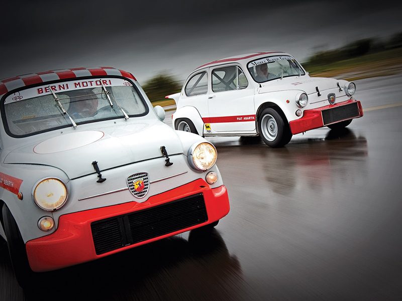 Zwei Fiat 600 Abarth auf regennasser Fahrbahn