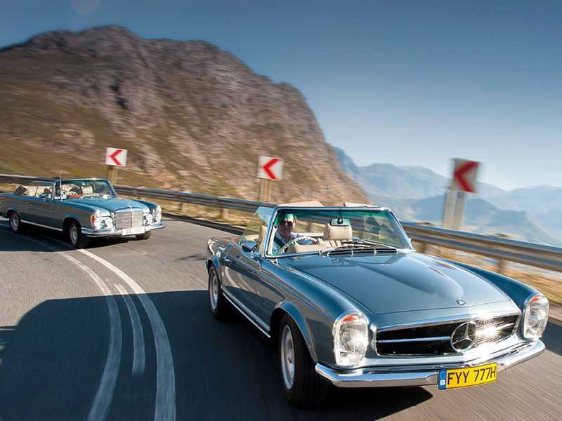 Zwei Mechatronik-Mercedes auf Kurvenfahrt: 280 SE (hinten) und 280 SL (vorne)