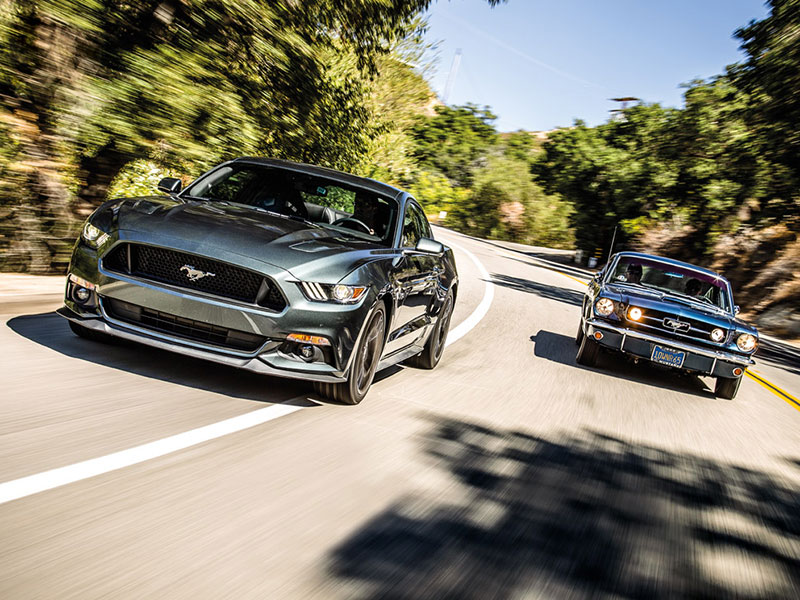 Ford Mustang V8 GT, Bj. 2015, fahrend neben Ford Mustang 289 Fastback, Bj. 1965